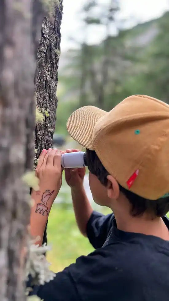 Enfant observant la nature avec le microscope de poche Kidscop